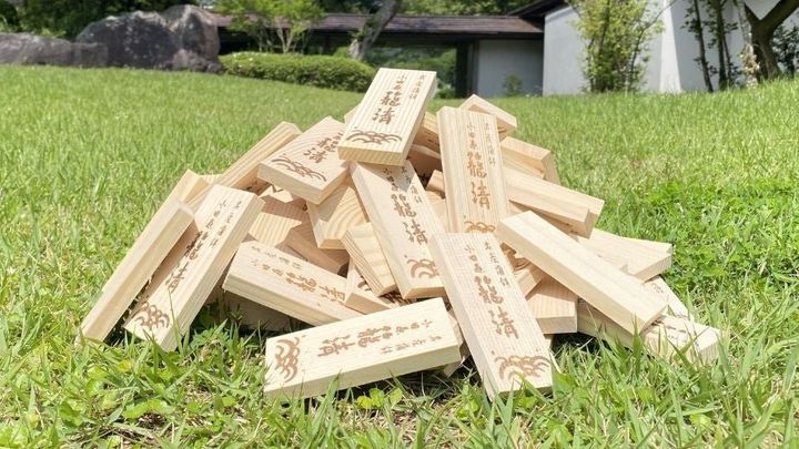 芝生に積まれた籠淸の焼印入りかまぼこ板