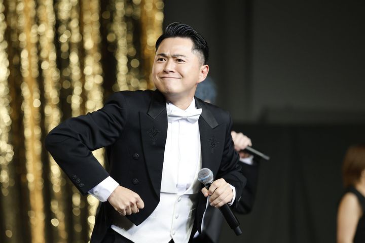 ステージでマイクを構えるケーシーハシモトさん