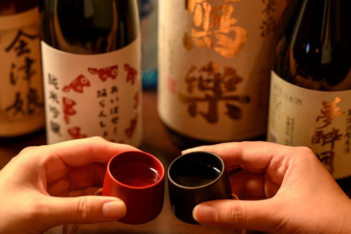 会津漆器のお猪口で地酒に乾杯する様子