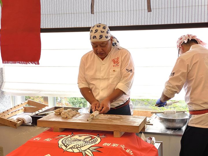 すり身を竹の棒に巻いてちくわを成形する職人