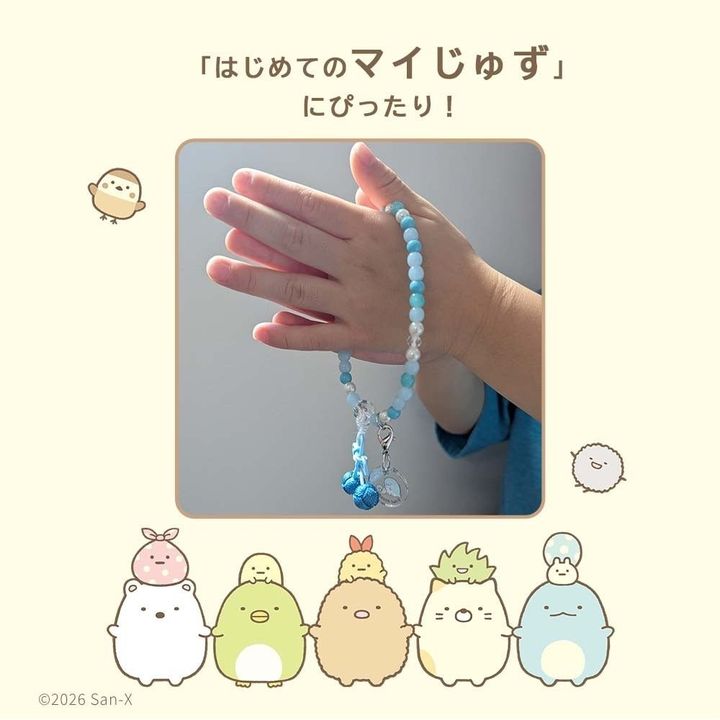 水色の数珠を手にはめて手を合わせる子ども