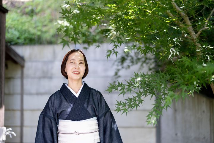 浴衣姿の女性が箱根リトリートの庭を背景に立つ様子