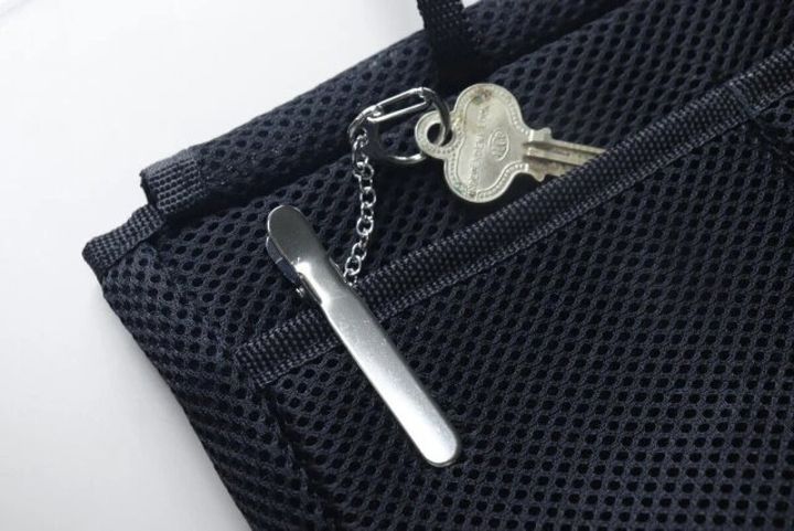 黒いバッグの内ポケットに銀色のキークリップと鍵が挟まっている