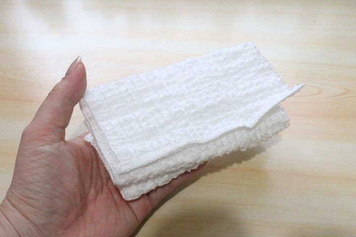 手のひらに乗せた白いコンパクトなボディタオル