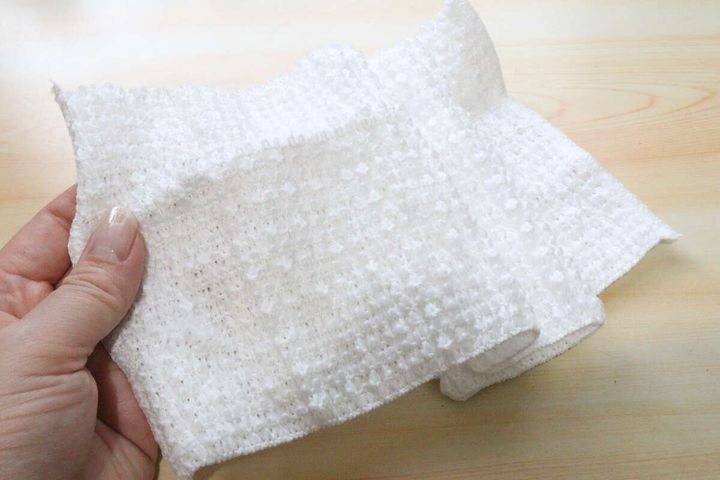 広げて見せる白いボディタオルの伸びる生地