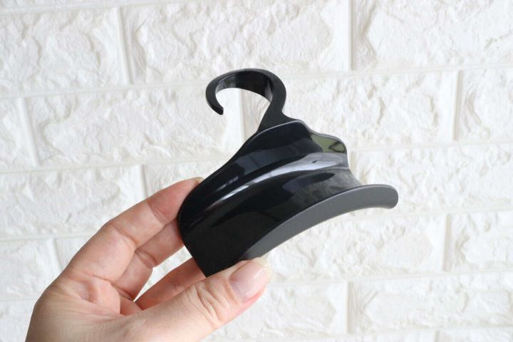 手に持った黒い車用バッグフック。特徴的なカーブが見える