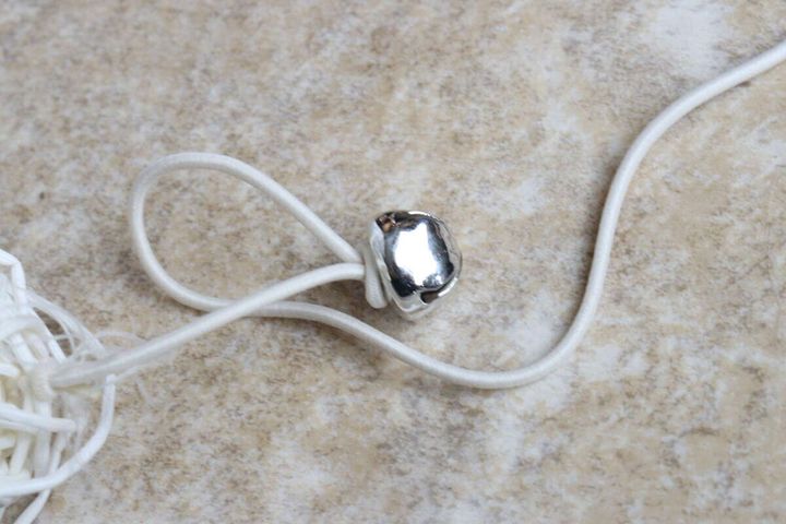 猫用おもちゃの紐に付いている、銀色の鈴のクローズアップ