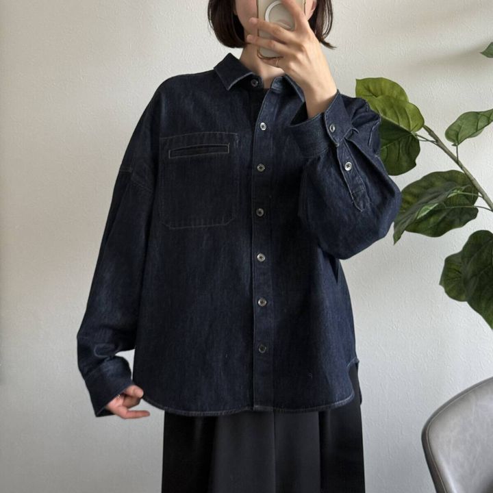 女性がデニムシャツジャケットのボタンを閉めて自撮り