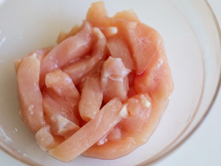 ボウルに入った鶏むね肉に塩とにんにくが揉み込まれている