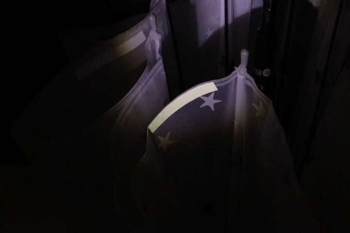 暗い場所で傘に貼られた反射ラベルが車のライトを反射して光る
