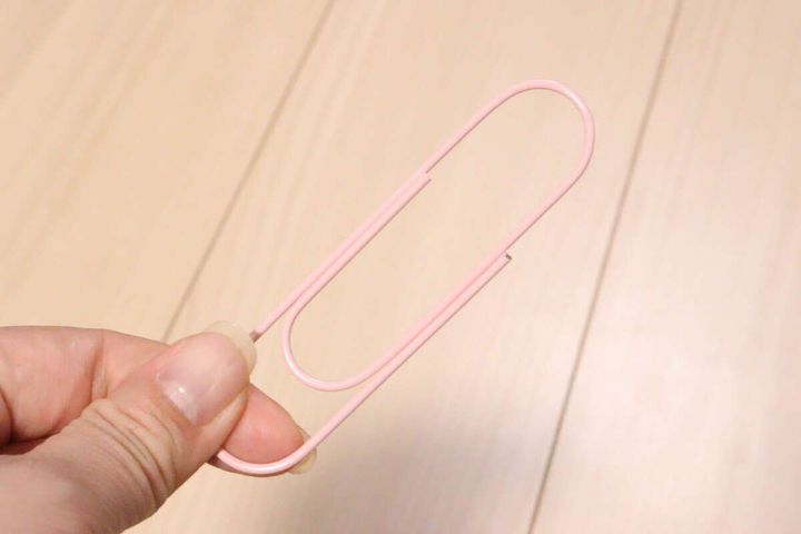 女性の指がピンクのビッグクリップを一本持っている様子
