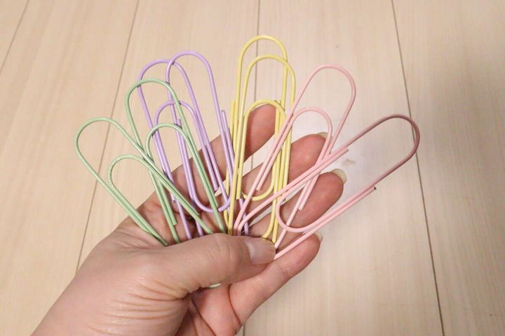 女性の手のひらにカラフルなビッグクリップが複数乗っている