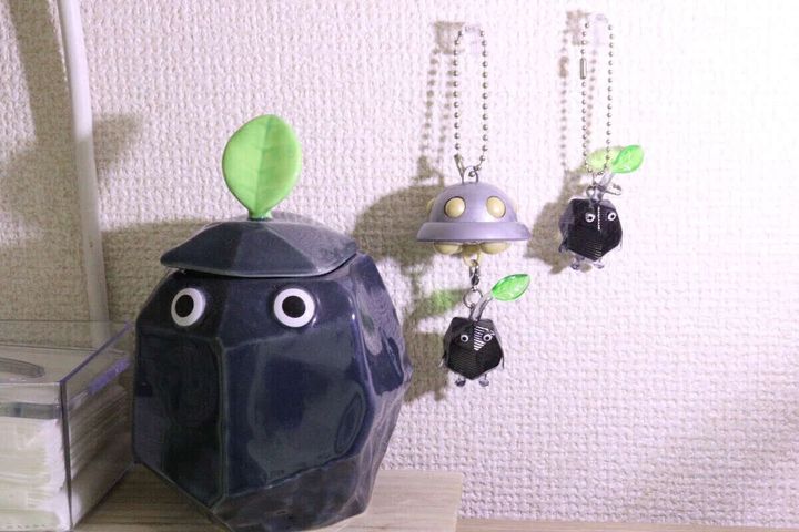 壁に掛けられたピクミンのキーホルダーと岩ピクミン風の置物