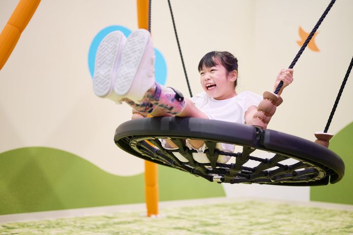 インクルーシブブランコに仰向けで乗る子ども