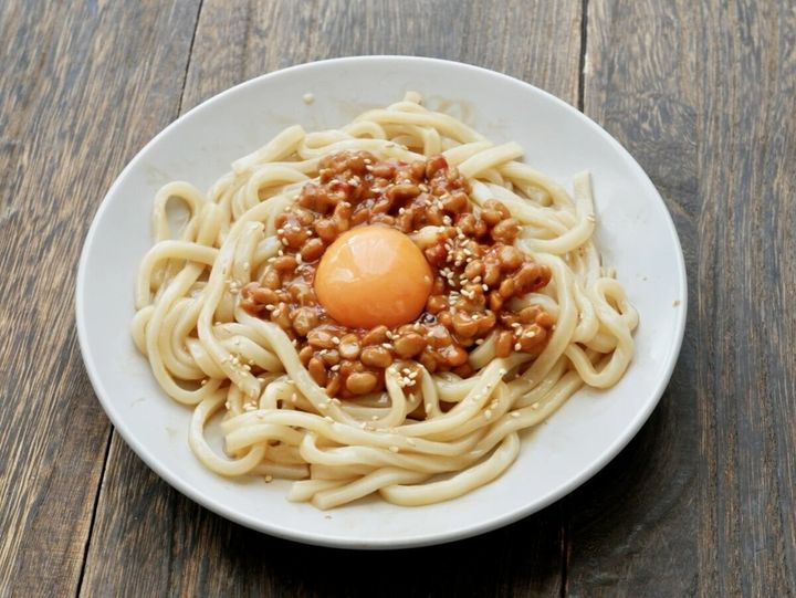 卵黄と白ごまがのった納豆まぜうどん