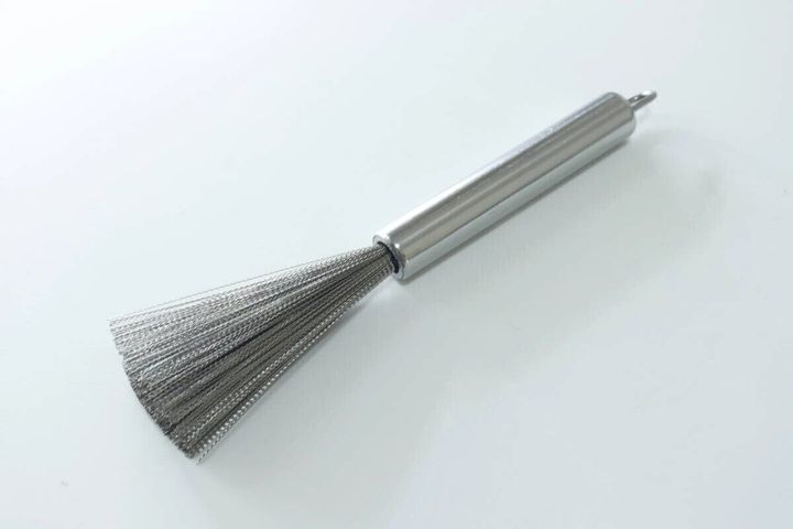 白い背景に置かれた中華鍋用ステンレスブラシ
