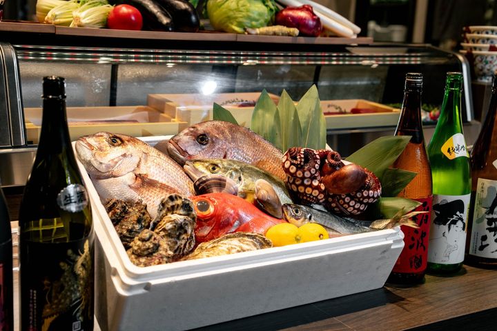 「トリノイチ」の店名の由来となった旬の魚介と野菜、日本酒が並ぶ様子