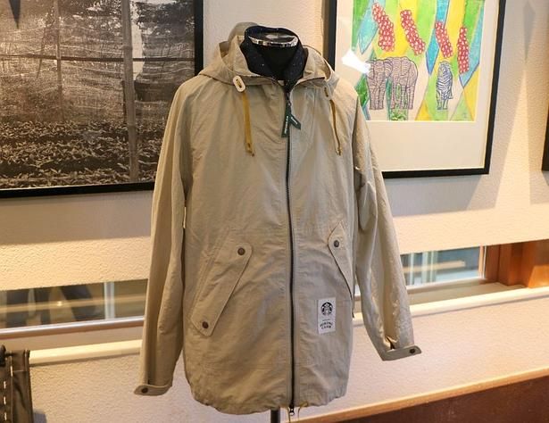 「and wander + STARBUCKS ナイロンタフタフーディージャケット」のアイボリー