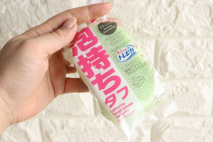 女性が「泡持ちタフスポンジ トレピカ」のパッケージを手に持つ