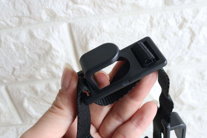 女性の手がヘッドレスト用お買い物フックの固定パーツを指す