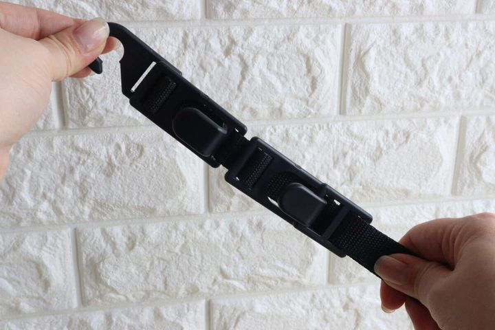 女性の手がヘッドレスト用お買い物フックの長さを調整している