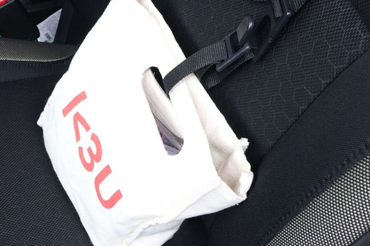 ヘッドレスト用お買い物フックに白い布製バッグが固定されている
