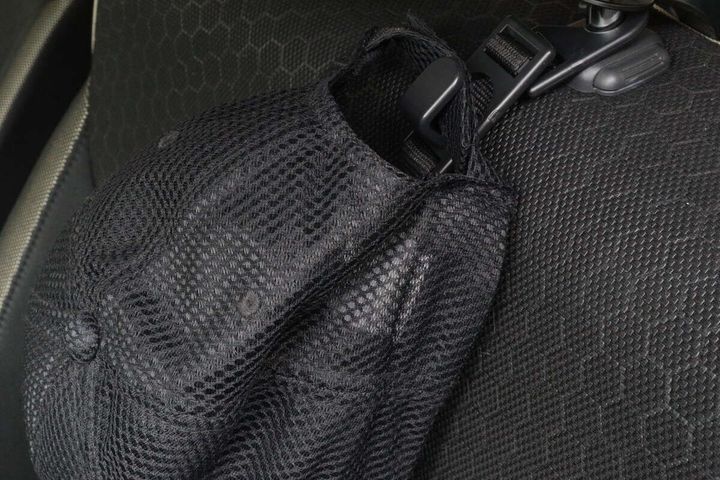ヘッドレスト用お買い物フックに黒いメッシュキャップが掛けられている