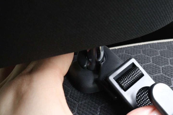 車のヘッドレストのポールにフックを取り付けている様子