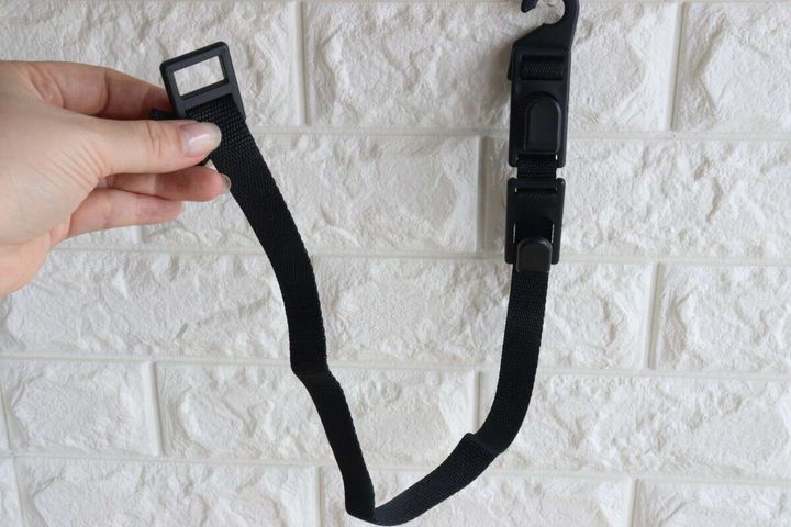 女性の手がヘッドレスト用お買い物フックを伸ばして持つ