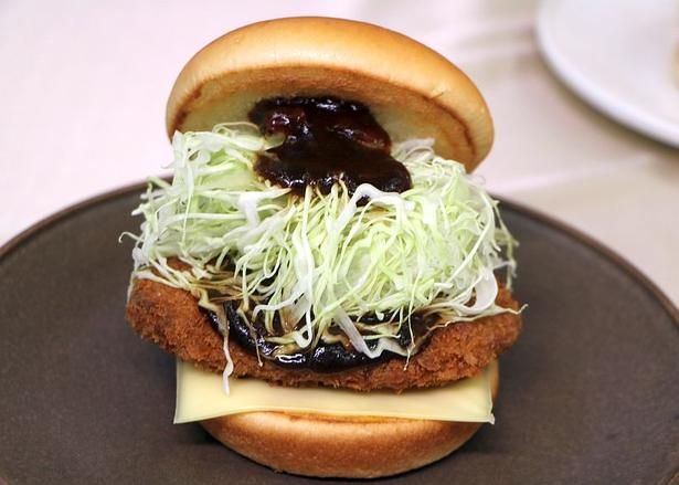 隠し味として加えたバルサミコ酢のおかげで軽さのある味わいに。「メンチカツチーズバーガー ～デミグラスソース～」