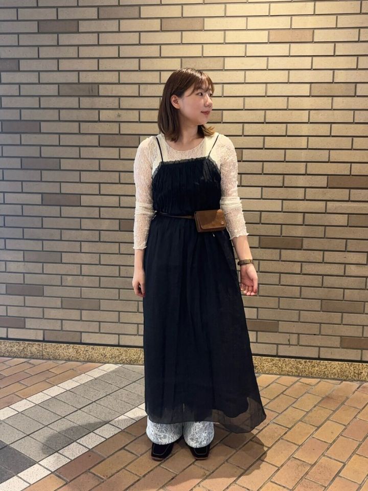 黒キャミワンピに白レーストップスとボトムスを重ね着した女性