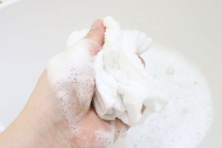 手でボディタオルを揉み込み白い泡をたっぷり立てている