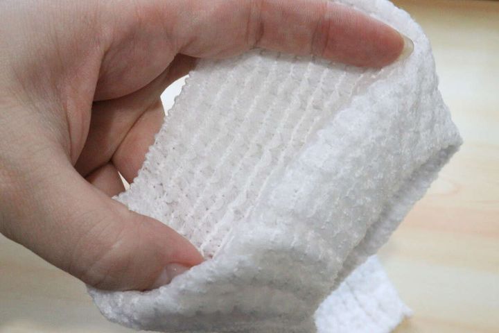 手で掴んでボディタオルの伸縮性と生地の質感をアップで示す