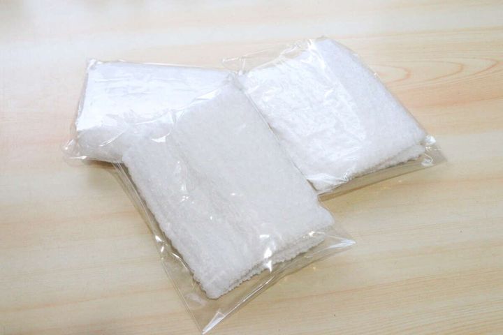 個包装された白い使い切りボディタオルが2つ並んでいる
