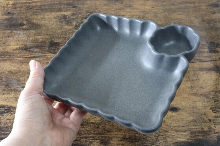 手が持っている黒い深皿仕切り皿