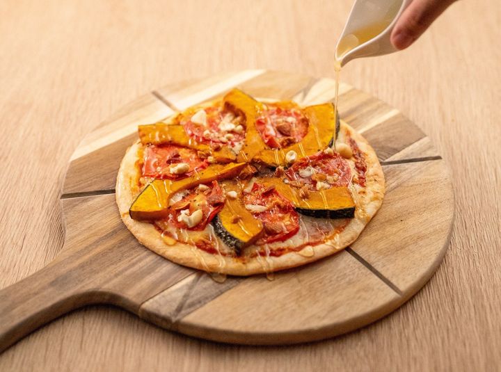 1. 山形ならではの秋の実りを味わう、彩り豊かな限定メニュー / かぼちゃとトマトのハニーピザ（1,780円）：ほくほく甘い秋のかぼちゃに、トマト・ベーコン・チーズをたっぷり乗せて焼き上げました。ナッツのアクセントと、仕上げにかけるはちみつの甘じょっぱいハーモニーがクセになる一品です。