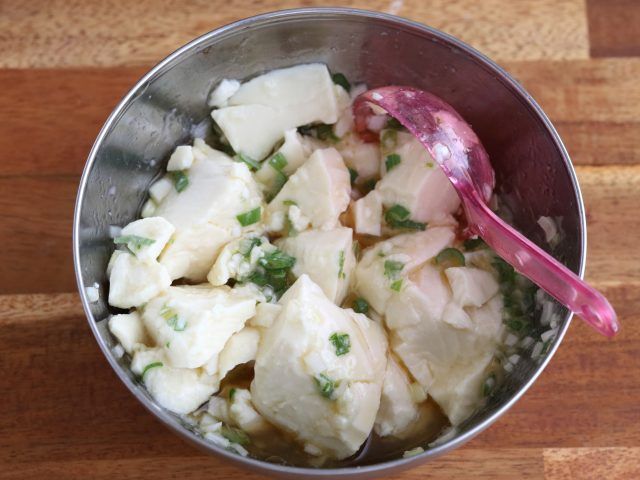 絹ごし豆腐とねぎ塩だれを和える様子
