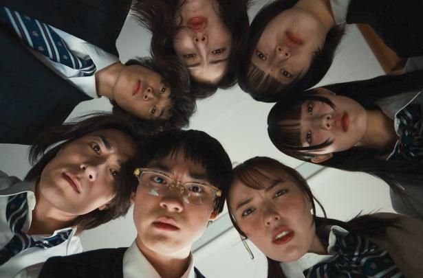 スマホの画面を上から覗き込むユラと同級生たち [c]「呪いのスマホ」製作委員会