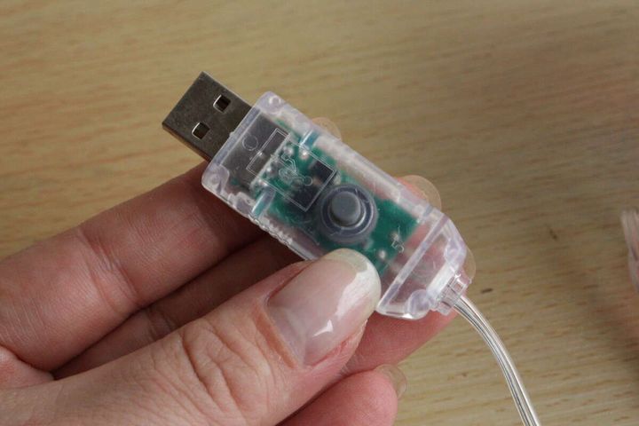 指でUSBコネクタ部分のスイッチを押しているクローズアップ