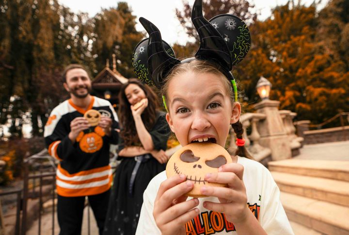 ジャック・スケリントンの顔をかたどった焼き菓子を口に運ぶ子ども