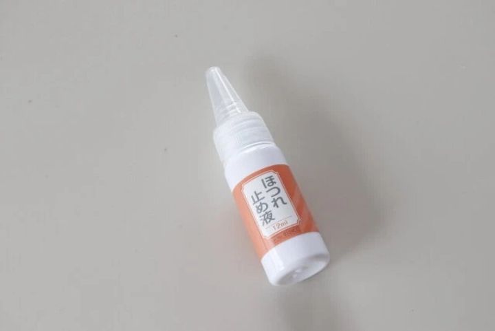白い背景に置かれた「ほつれ止め液」のボトル