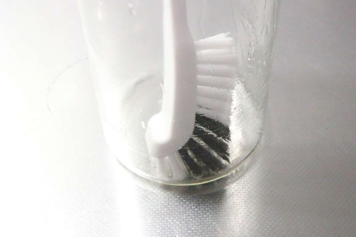 ダイソーのボトル洗いブラシでガラスポットの底を洗っている様子
