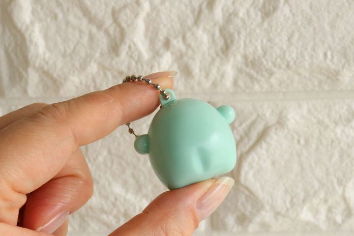 女性の指が水色のじゃんけんキーホルダーの裏側を持っている