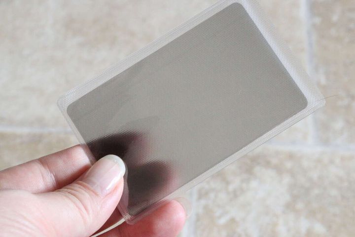 指で持った透明なカードケースとグレーの覗き見防止フィルター