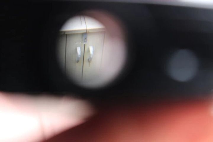 双眼鏡を覗いた視界で遠くの棚が拡大されて見える様子