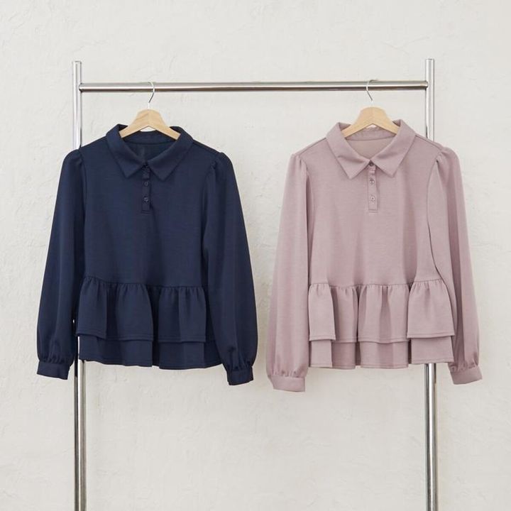 紺色とピンクベージュの襟付き二段ペプラムトップスがハンガーにかかっている