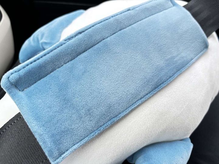 車のシートベルトに青いサメクッションを取り付けた様子
