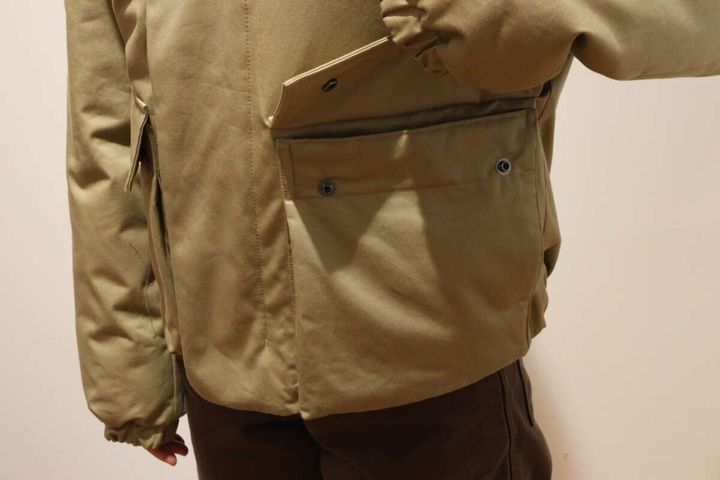 ベージュのダウンジャケットのサイドポケット部分