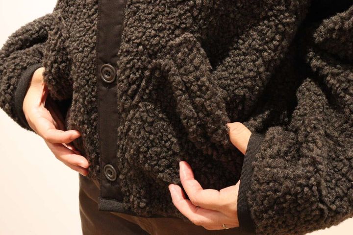 ブラックのフリースジャケットのポケットに手を入れる