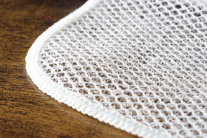 白いメッシュクロスの粗いメッシュ素材とループ状の繊維の接写
